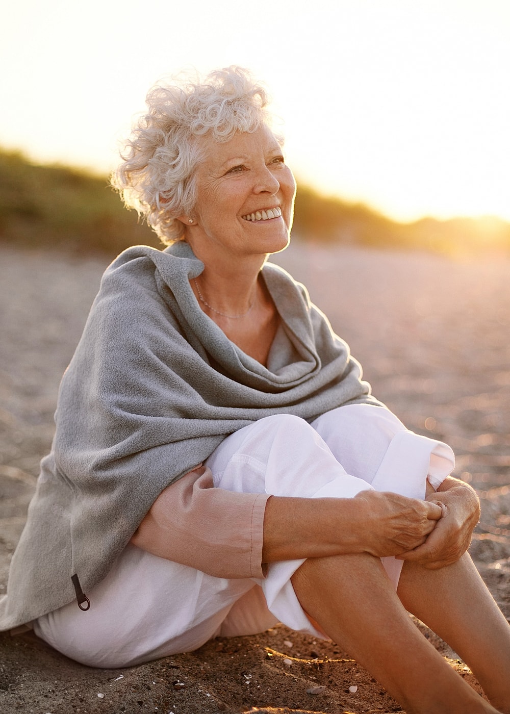Woman playing with hair in stylish outfit.