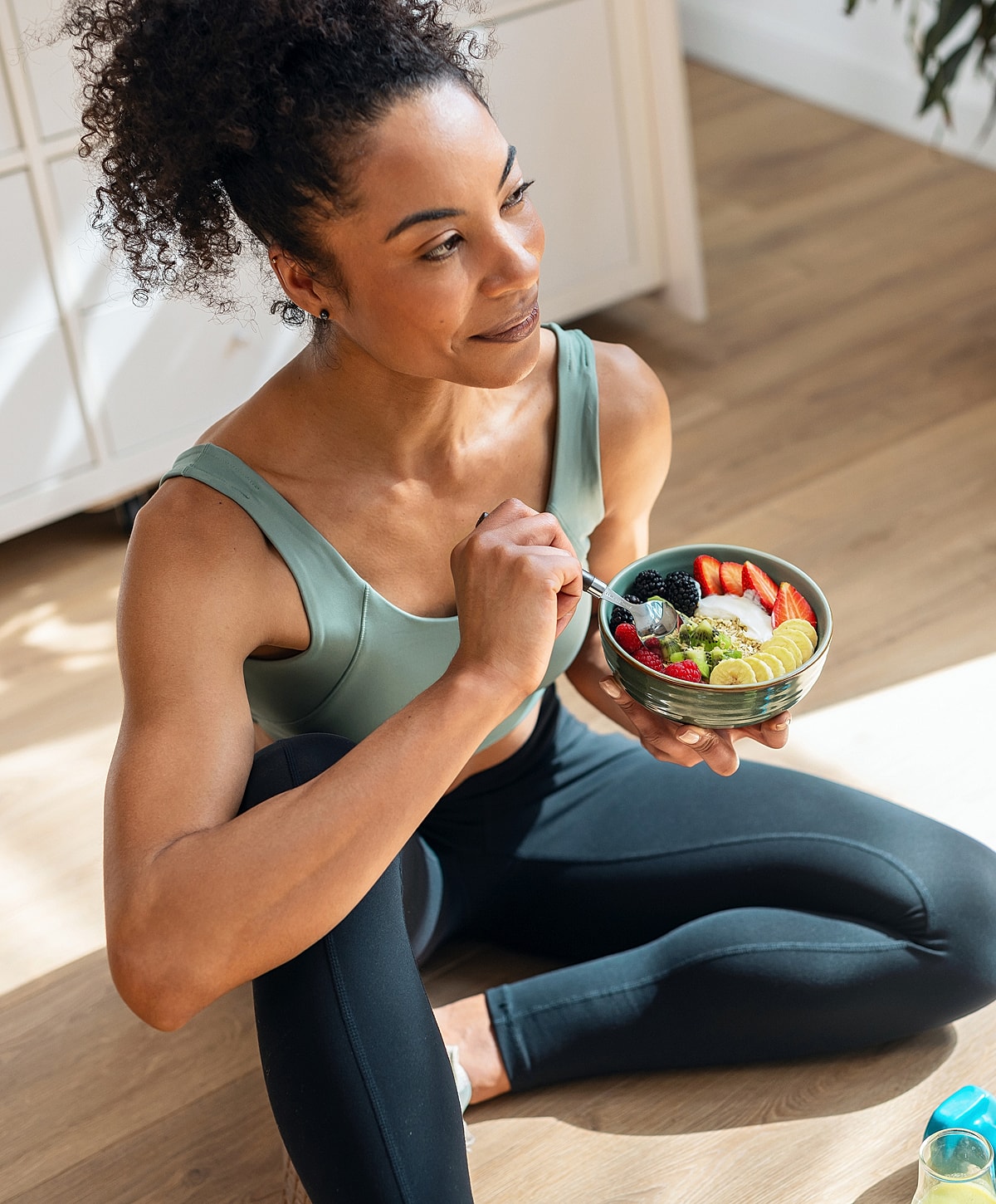 Woman enjoying a healthy fruit bowl snack.