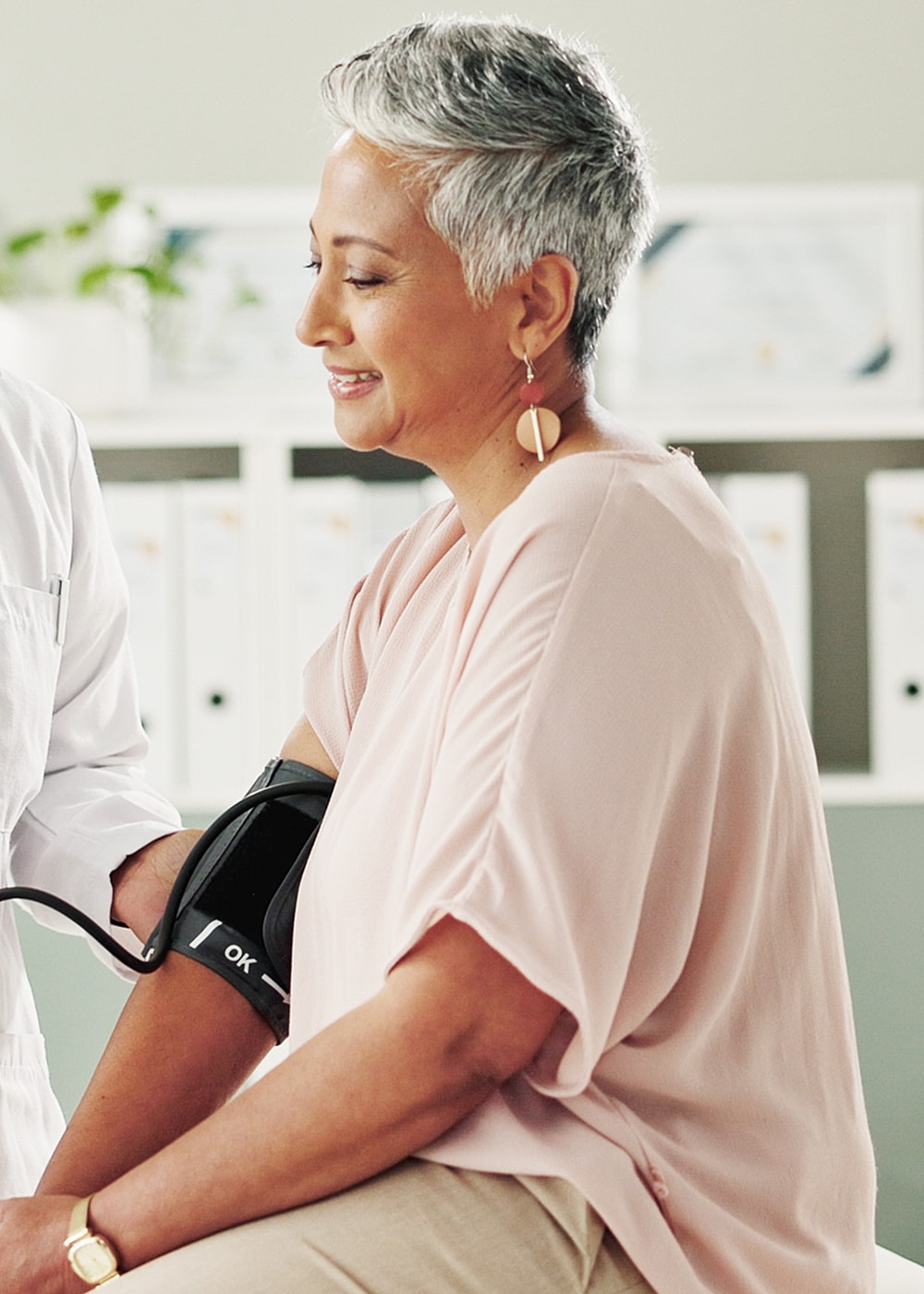 Woman receiving a blood pressure check in clinic.