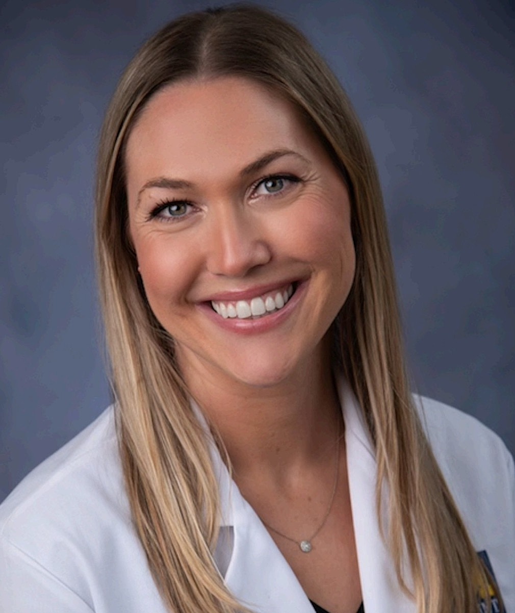 Smiling woman in a white lab coat.